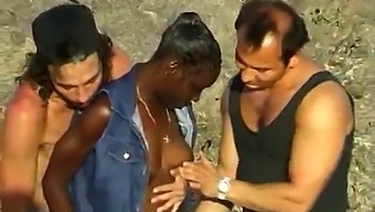 非洲女人在海边与两个白人男子享受三人行